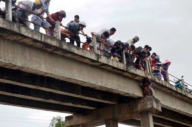 Người hiếu kỳ đứng xem chật kín trên cầu Tân Hạnh và hai bên bờ sông.