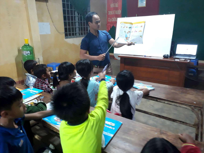 Thầy Lo Minh kèm các em nhỏ học. Ảnh: Nhân vật cung cấp