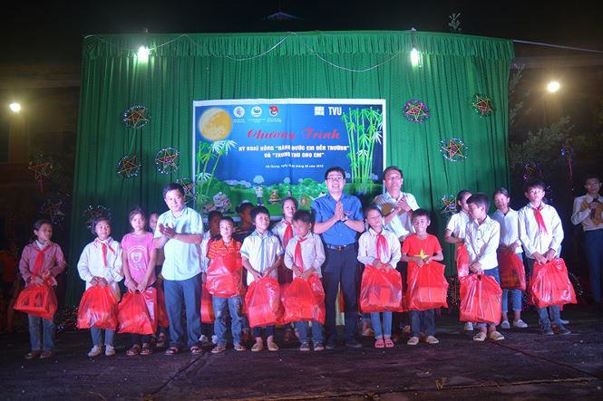 Anh Nguyễn Thái Hà - Bí thư Đoàn Cơ quan T.Ư Đoàn và lãnh đạo xã Ngọc Linh trao quà cho các em thiếu nhi.  Ảnh: X.A