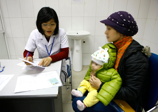 Đưa trẻ đi khám dinh dưỡng ở một trạm y tế Hà Nội. ảnh: như ý