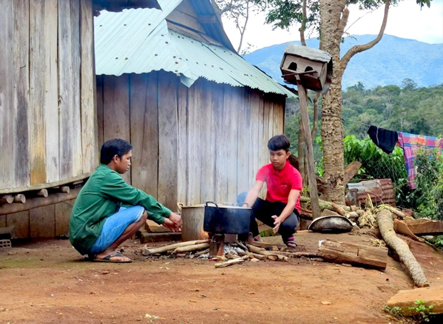 Học sinh lớp 9 Đinh Hợi (phải) và bố nấu ăn ngoài trời 