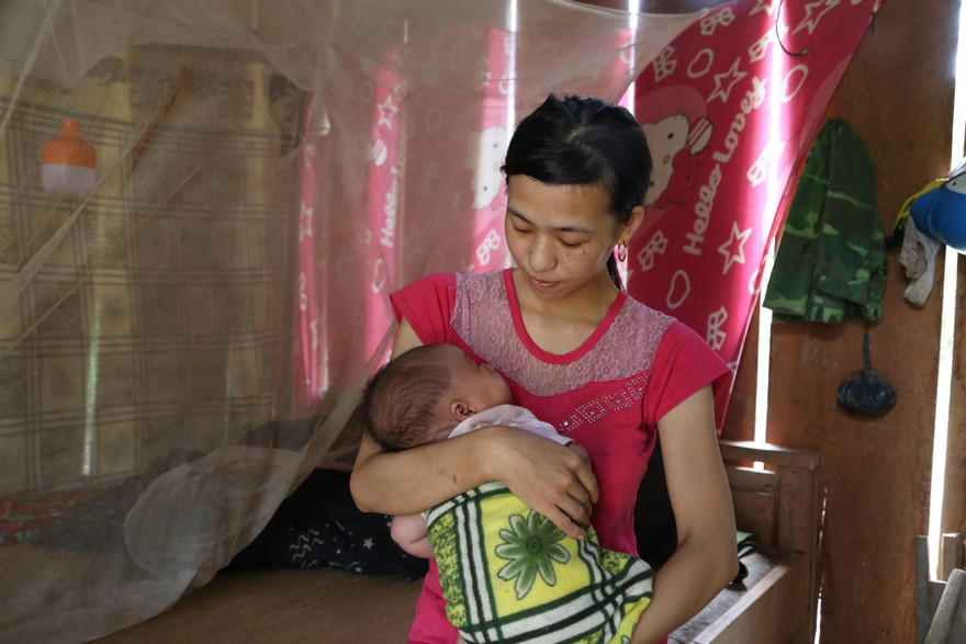 Chị Phùng A Tranh (vợ anh Xồng Bá Xò) bế đứa con hơn 1 tháng tuổi trên tay vui mừng khi đã được trở về quê