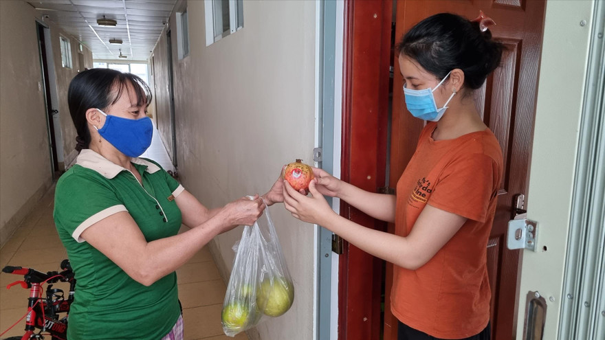 Chị Châm Anh (phải) mua trái cây từ “siêu thị” hàng xóm. Ảnh: Thanh Trần 