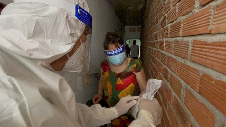 Nhân viên y tế phát thuốc điều trị tại nhà cho F0 