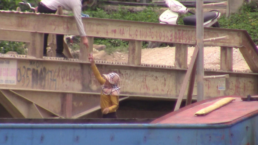 Chủ tàu (dưới) đưa tiền cho nhân viên cảng vụ tại khu vực Thanh Liêm (Hà Nam)