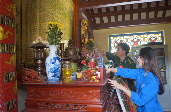 Cán bộ Đồn Biên phòng Pò Hèn và ĐVTN xã Hải Sơn dọn dẹp nơi thờ tự các anh hùng liệt sĩ trong khuôn viên khu di tích Pò Hèn Ảnh: N.M 