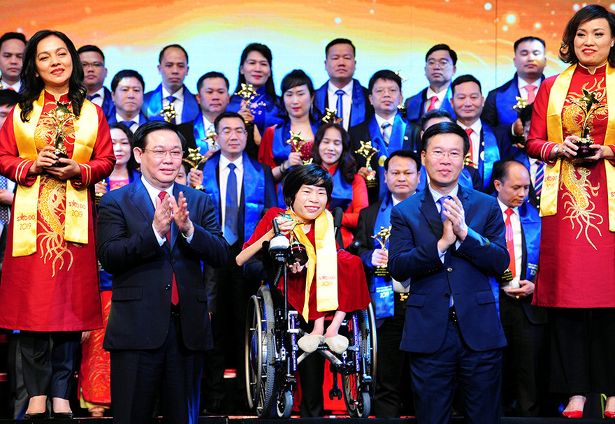 Phó Thủ tướng Vương Đình Huệ và Trưởng ban Tuyên giáo Trung ương Võ Văn Thưởng dự và trao giải thưởng cho Top 10 Doanh nhân Sao Đỏ năm 2019 và danh hiệu Sao Đỏ danh dự cho chị Nguyễn Thị Vân (ngồi xe lăn) trong chương trình.ẢNH: xuân tùng