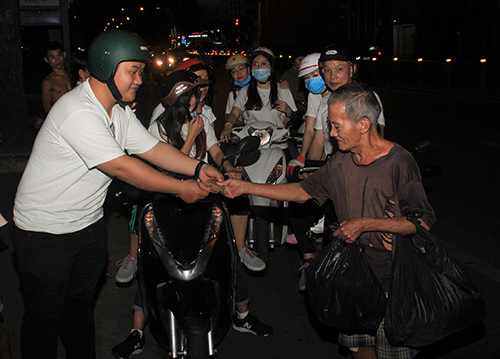 Bạn trẻ mang “Tết yêu thương” đến với người vô gia cư trên hè phố TPHCM Ảnh: NGÔ TÙNG