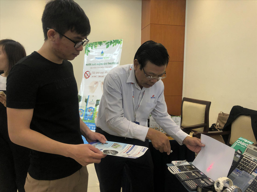 Doanh nghiệp rất bức xúc trước sản phẩm bị làm giả nhưng cũng ngại lên tiếng. Ảnh: chiếu đèn laser lên tem chống giả để phân biệt hàng thật - giả 