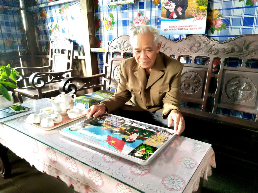 Ông Bảo xem lại những hình ảnh kỷ niệm thời quân ngũ.