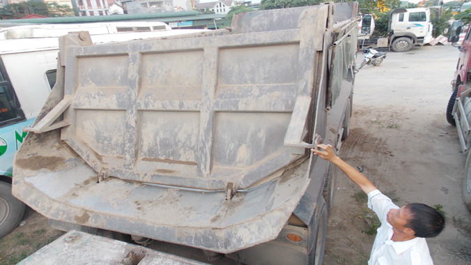 Lái xe 29C-17457 cho rằng, tụt chốt ben là nguyên nhân để bùn thải đổ ra đường, trong khi ngoài chốt tay, cửa thùng ben còn có chốt cơ. Ảnh: Anh Trọng.