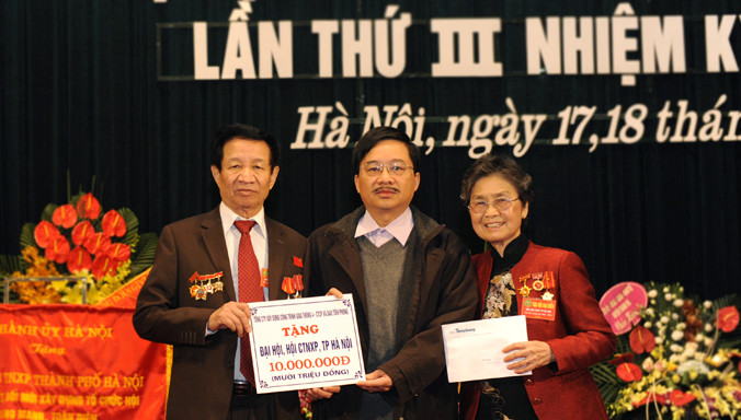 Phó Tổng biên tập báo Tiền Phong, nhà báo Vũ Tiến, trao tặng số tiền 10 triệu đồng cho Chủ tịch Hội Cựu TNXP Hà Nội Đỗ Quốc Phong (ngoài cùng bên trái ảnh).