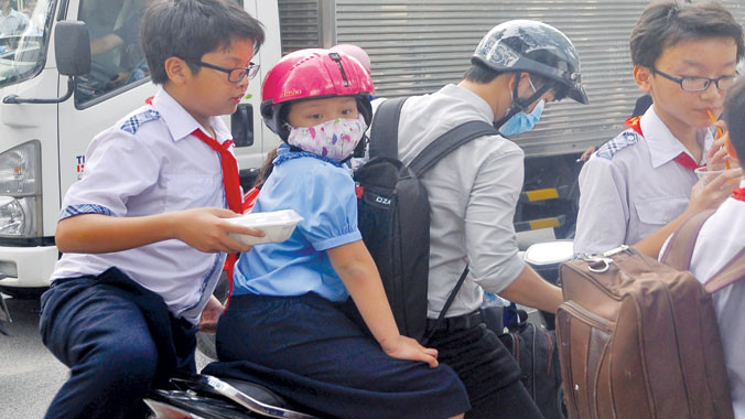 Sau giờ tan trường, phụ huynh liền cho con ăn vội thứ gì đó rồi tiếp tục chở con đi học thêm.