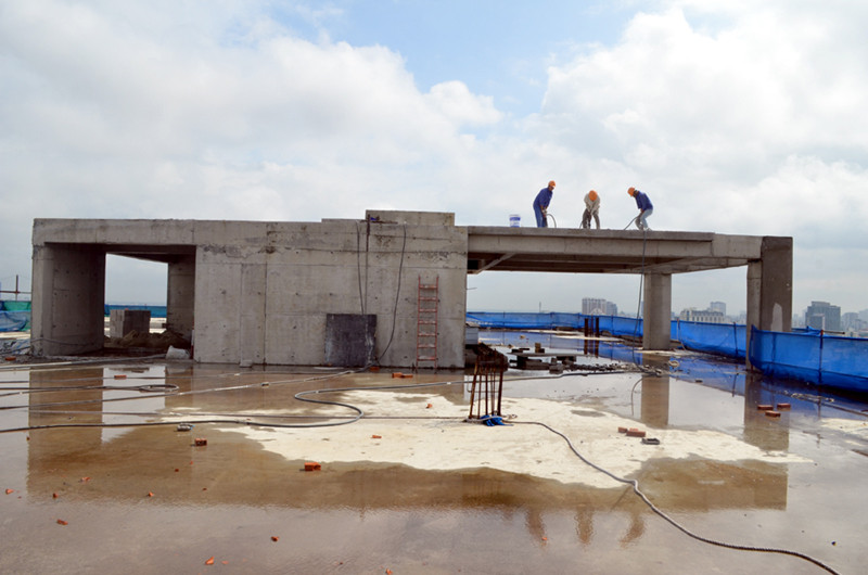 Ba công nhân dùng máy khoan tay phá dỡ tum tòa nhà 8B Lê Trực. Ảnh: Dân trí