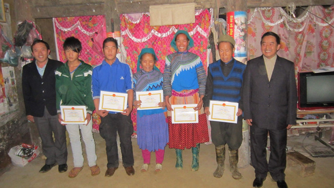 Chủ tịch xã Mản Thẩn Giàng Seo Châu (ngoài cùng bên trái) tặng quà cho các hộ dân ở xã.