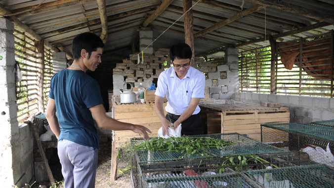 Phó Chủ tịch xã Quế Sơn (Sơn Động, Bắc Giang) Trần Sỹ Trung (bìa phải) hướng dẫn thanh niên nuôi thỏ. Nhiều hộ dân Quế Sơn thoát nghèo nhờ dự án nuôi thỏ do anh Trung đề xuất. Ảnh: Xuân Tùng.
