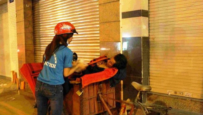 Thành viên Đội CTXH của HUTECH phát cháo cho người lao động nghèo trong đêm. Ảnh: Đội Công tác xã hội HUTECH cung cấp.