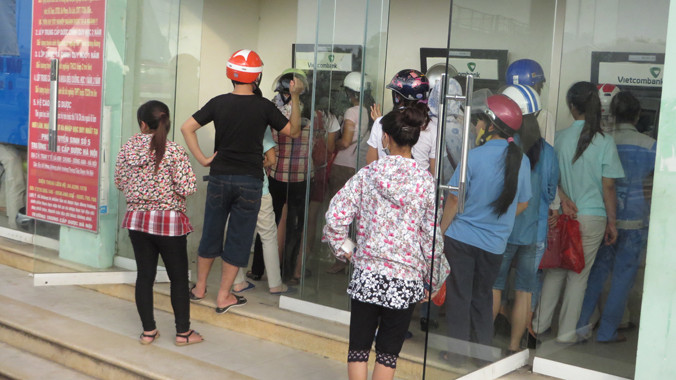 Lẫn trong dòng người xếp hàng, có nhiều chủ tiệm cầm đồ cầm thẻ ATM của công nhân đi rút tiền. Ảnh: Quỳnh Nga. 