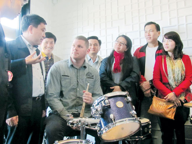 Anh Jimon Wilson, giám đốc Oxigen giới thiệu với Bí thư Thường trực Trung ương Đoàn Nguyễn Mạnh Dũng (mặc áo khoác đen đứng hàng đầu bên trái) và các cán bộ làm công tác thanh niên của Việt Nam về những dịch vụ trợ giúp thanh niên.