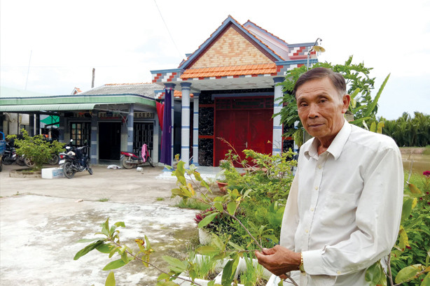 Ông Nguyễn Văn Danh chăm sóc kiểng trước nhà. Ảnh: Hòa Hội.