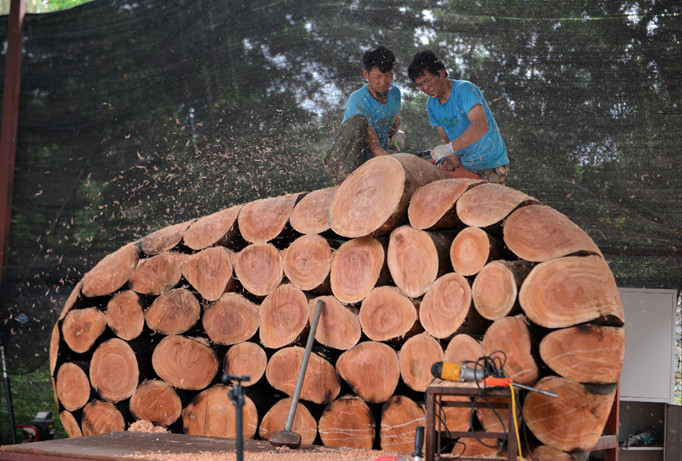 Điêu khắc gia Lee Jae Hyo đem theo cả một trợ thủ từ Hàn Quốc sang Việt Nam cùng làm tác phẩm trên chất liệu gỗ xà cừ. Ảnh: BTC.