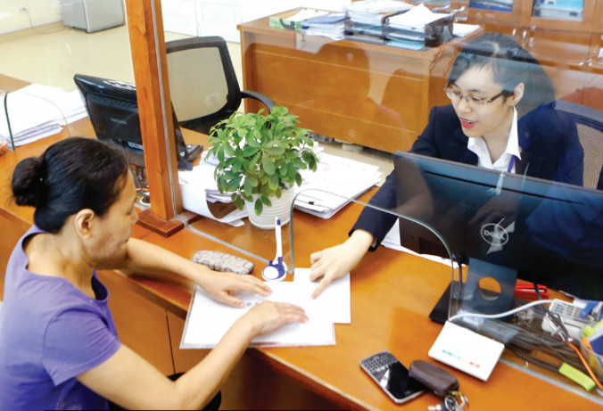 Trung ương vừa ra nghị quyết về tiếp tục đổi mới, sắp xếp lại tổ chức bộ máy tinh gọn, hiệu quả (Trong ảnh: Người dân làm thủ tục tại bộ phận một cửa tại UBND quận Ba Đình, Hà Nội). Ảnh: Như Ý.