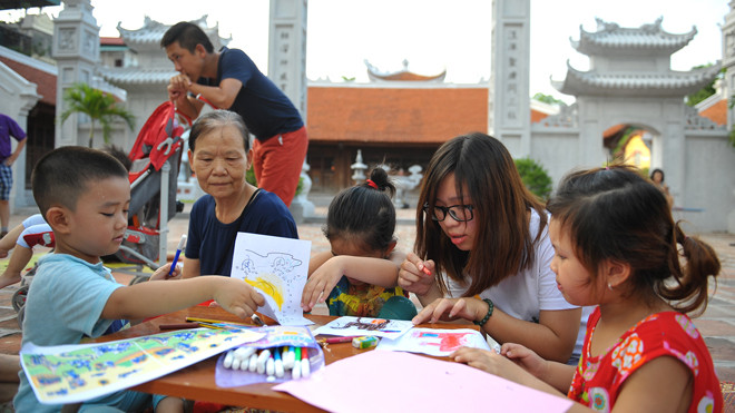Các em nhỏ tham gia tô màu cho tranh, ghép tranh với sự hướng dẫn của các anh chị tình nguyện viên. Ảnh: Xuân Tùng.