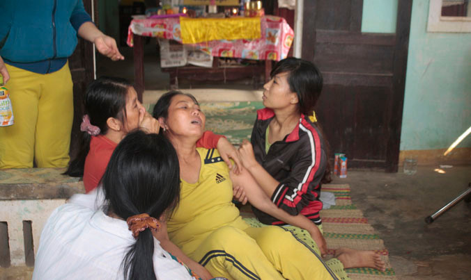 Bà Ngô Thị Hai khóc ngất bên quan tài con trai Nguyễn Minh Hoàng. Ảnh: Nguyễn Thành.