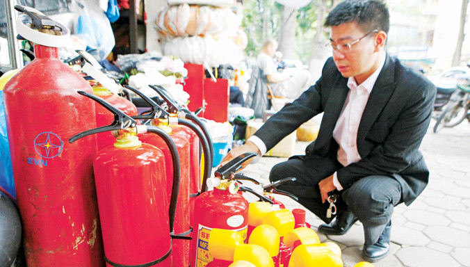 Trang bị bình cứu hỏa mini trên xe ô tô con hiện chỉ để đối phó. Trong ảnh: chọn mua bình cứu hỏa cho xe con ở Hà Nội. Ảnh: Như Ý.