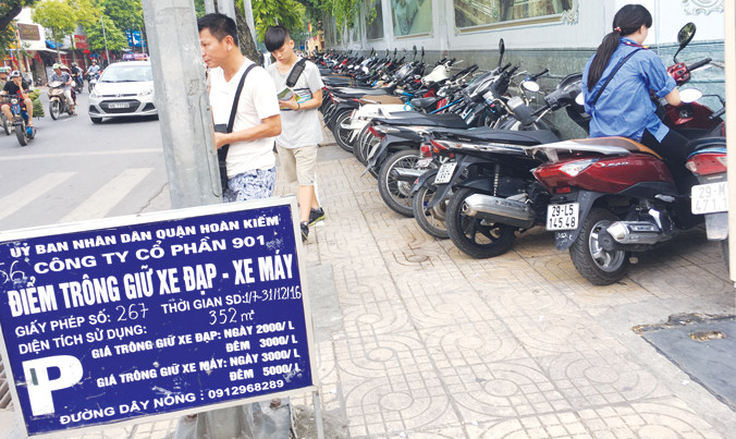 Bảng niêm yết giá công khai, nhưng chiều qua nhân viên điểm trông xe tại vỉa hè phố Hàng Bài vẫn thu giá gần gấp đôi quy định. Ảnh: AT.