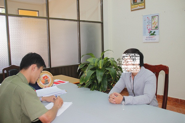 Đỗ Vũ Tuấn Anh (phải) tại cơ quan chức năng. Ảnh: Dân Trí