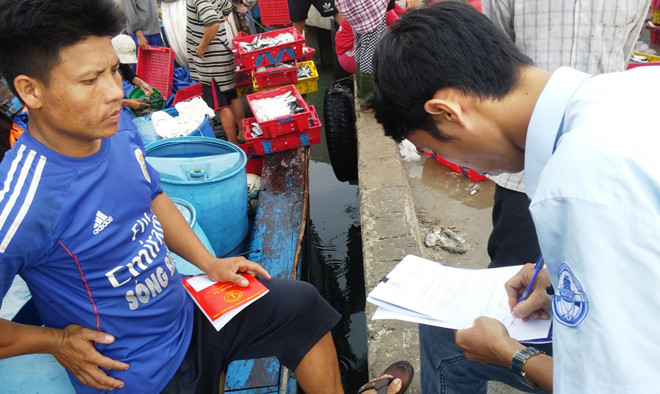 Cán bộ Chi cục Thủy sản TT-Huế ra tận tàu cá kiểm tra thủ tục và hướng dẫn ngư dân kê khai thông tin cấp chứng nhận thủy sản an toàn. Ảnh: Ngọc Văn.