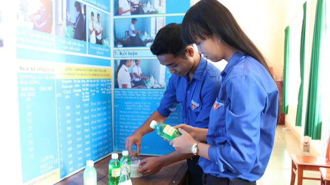 Điểu Linh và Hồng Hạnh bên cạnh sản phẩm sữa tắm đuổi muỗi do các em chế tạo.