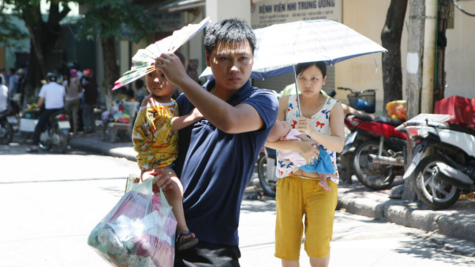 Tại cổng bệnh viện Nhi T.Ư, dòng xe nối đuôi nhau vào cổng bệnh viện, nhiều bố mẹ bế con đến viện vì con ốm do thời tiết nắng nóng. Ảnh chụp trưa 2/6. Ảnh: Như Ý.