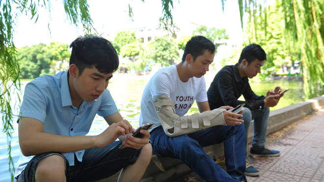 Phạm Mạnh Cường (thứ nhất từ trái sang) tranh thủ bắt xe buýt từ Ngã tư Vọng lên Hồ Gươm bắt Pokémon cùng với nhiều bạn trẻ khác trong chiều 8/8. Ảnh: Xuân Tùng.