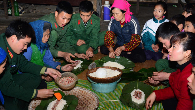Bộ đội và dân bản gói bánh chưng đón Tết.