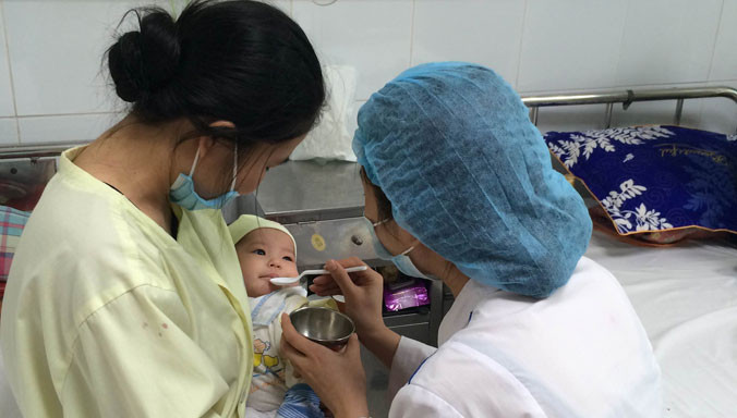 Bệnh nhi An Nhiên đang được uống thuốc điều trị ho gà. Ảnh: T.Hà.