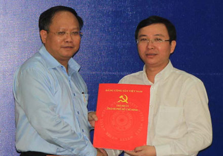 Phó bí thư thường trực Thành ủy TPHCM Tất Thành Cang (bên trái) trao quyết định phân công ông Đặng Quốc Toàn làm Bí thư Quận ủy Q.10