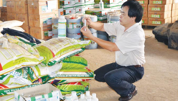 Chụp ảnh nhãn mác phân bón giả của Công ty Thuận Phong. Ảnh: H. Thiên Nga.