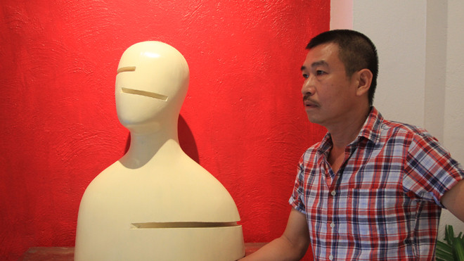 Lê Thiết Cương và “Chân dung 2” - tác phẩm trong triển lãm điêu khắc Mặt của anh. Ảnh: N.M.Hà.