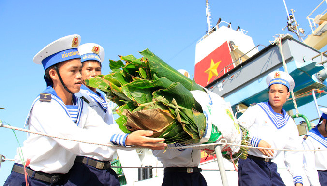 Các chiến sĩ vận chuyển lá dong gói bánh chưng xuống tàu đi Trường Sa. Ảnh: Trường Phong.