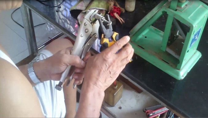 Thợ độ cân kéo dãn “lò xo” làm sai lệch cân chuẩn để gian lận. Ảnh: P.Hùng.