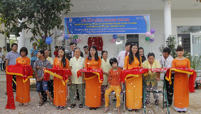 Bà, mẹ của những nạn nhân chất độc da cam cắt băng khánh thành Nhà nội trú cho trẻ bại liệt. Ảnh: Thanh Trần.