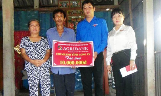 Anh Huỳnh Minh Tuấn trao quà cho gia đình có hoàn cảnh khó khăn.