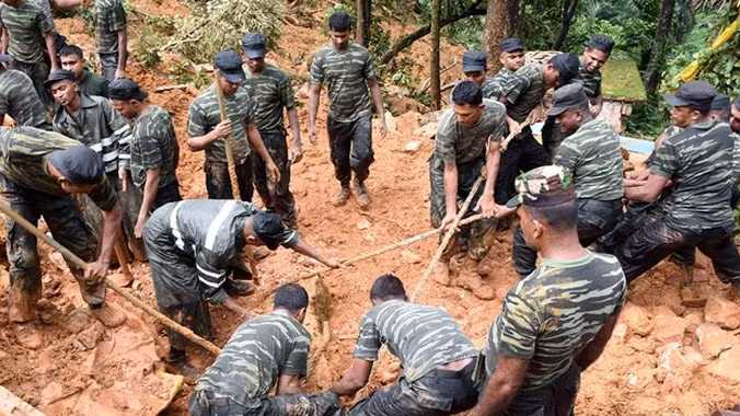 Binh lính Sri Lanka dùng xẻng đào bùn đất để tìm các nạn nhân. Ảnh: Guardian.