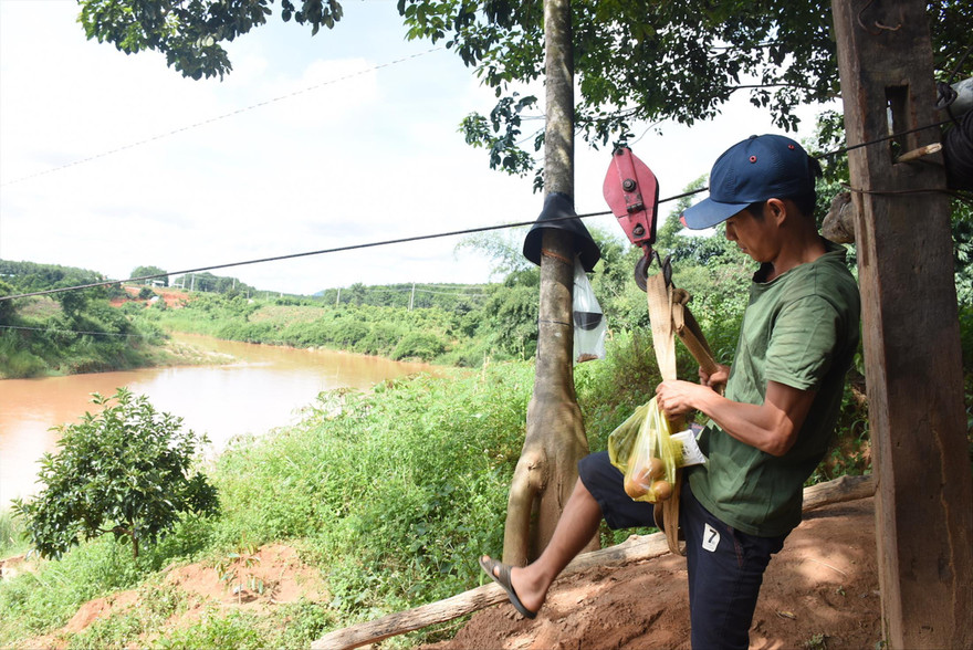 Người dân liều mình đu qua sông trên sợi dây cáp 