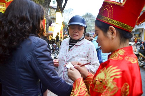 Nhân viên nhà hàng 'hóa trang' thần tài để giúp khách hàng viết phiếu, mua hàng. Ảnh: Thanh Hà