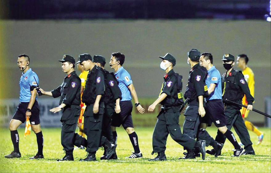 Lực lượng cảnh sát cơ động áp tải tổ trọng tài rời sân ở trận TPHCM và Thanh Hoá ngày 12/4 ảnh: CTV 