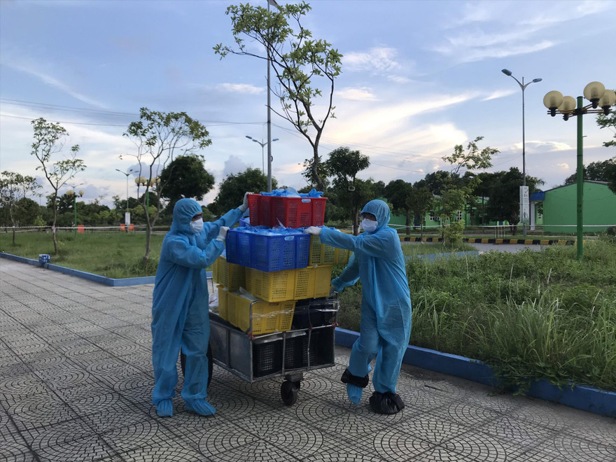 Các tình nguyện viên vận chuyển đồ ăn cho người cách ly