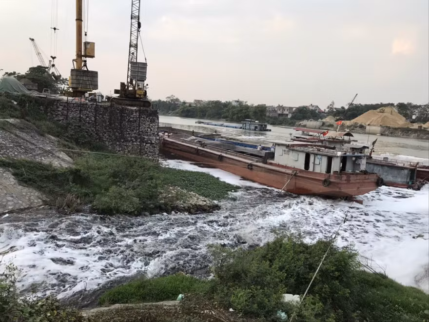 Nước từ kênh Tào Khê chảy ra sông Cầu đen như mực và trắng xóa bọt 